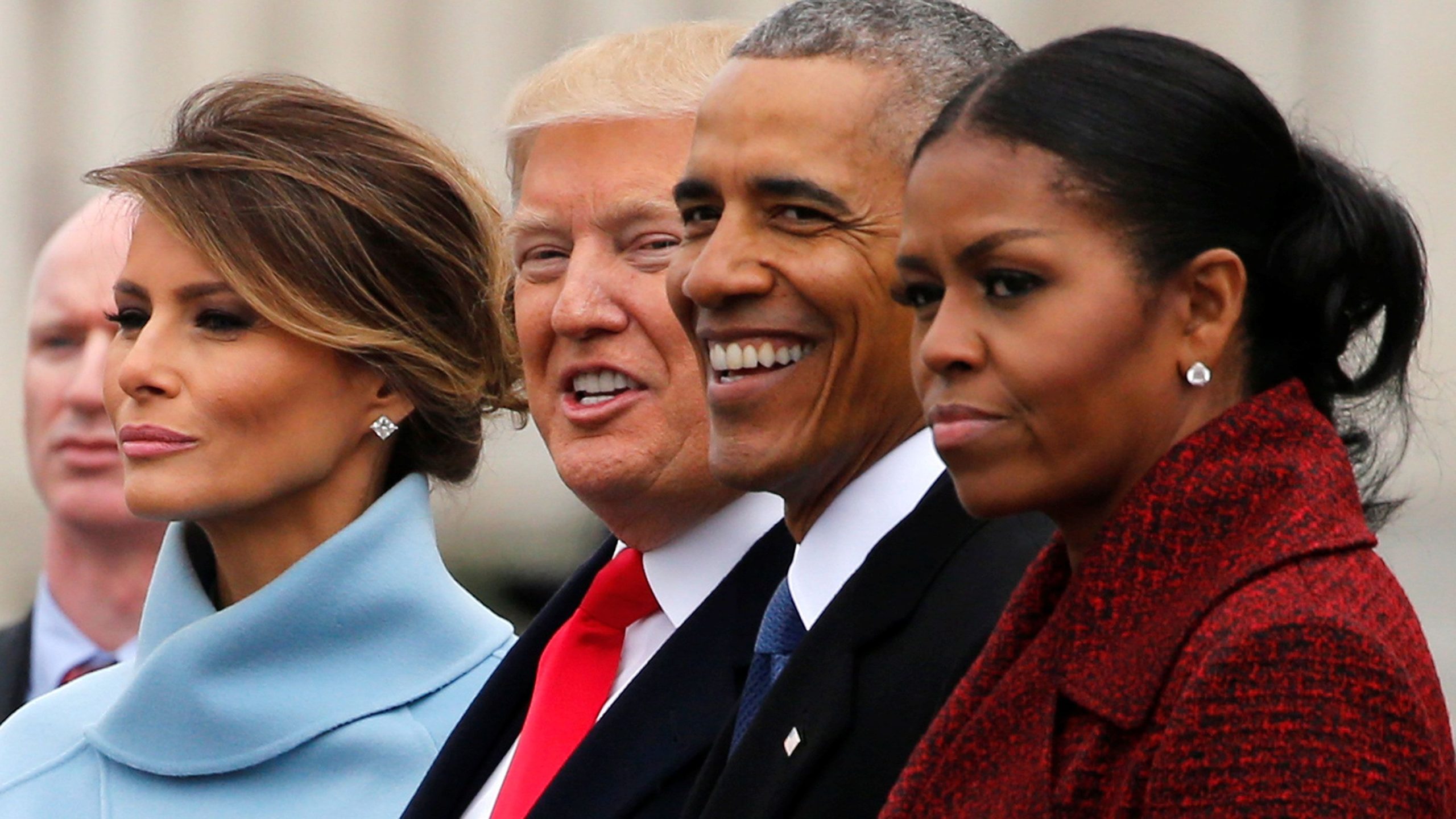 Barack and Michelle Obama stand smiling alongside Donald and Melania Trump during the 2017 presidential handover ceremony.