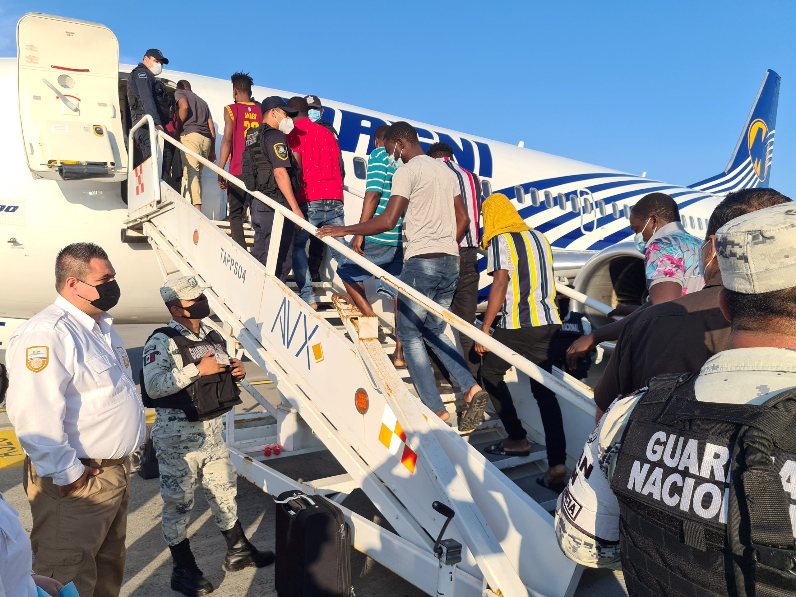 Haitian migrants board a plane leaving the United States under deportation orders.