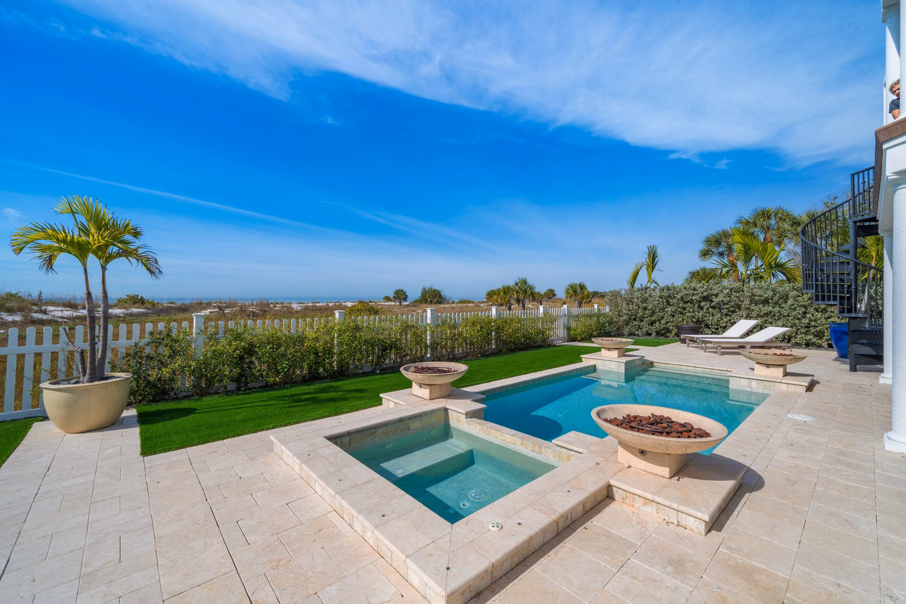 Expansive outdoor pool at Hulk Hogan’s Clearwater mansion, surrounded by lounge chairs and overlooking the Gulf’s white sand beaches.