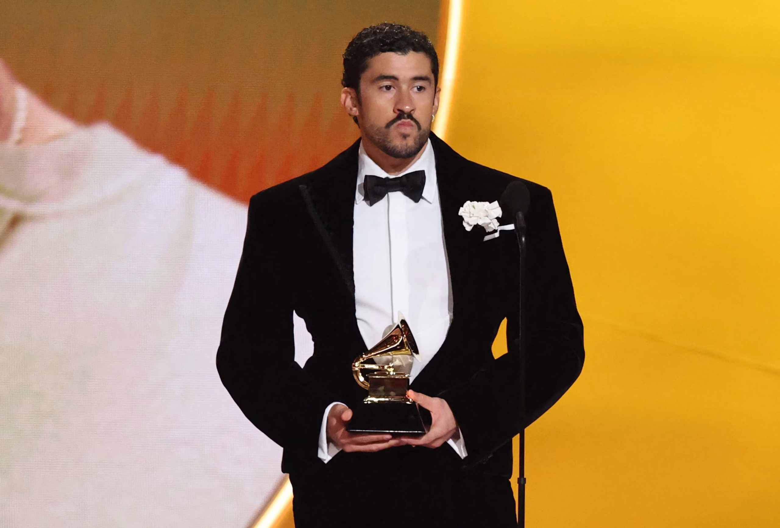 Bad Bunny accepts his Album of the Year Grammy on stage at the 2026 awards, holding the iconic gold gramophone.