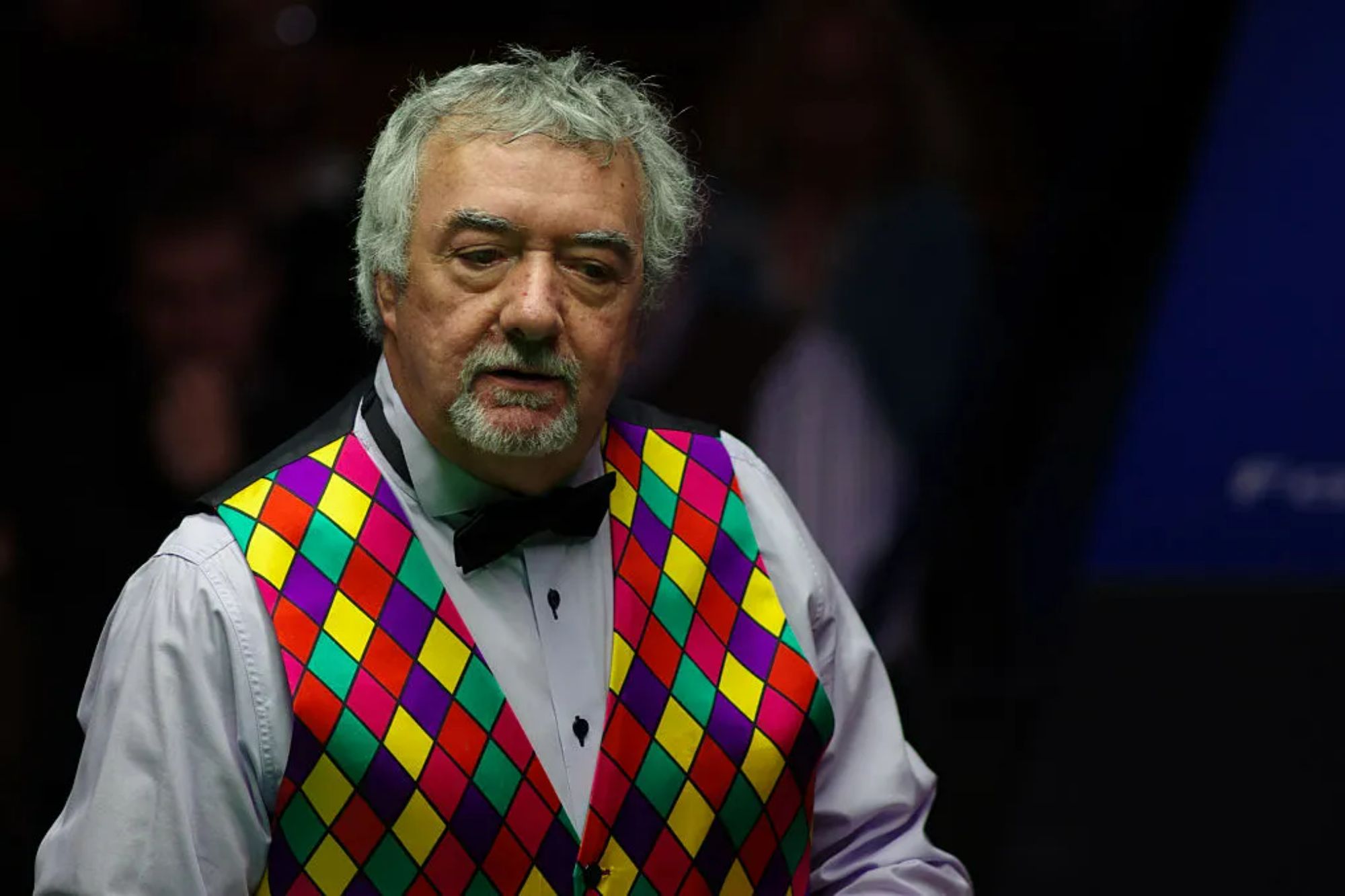 John Virgo wearing his iconic multicoloured suit vest during a snooker broadcast appearance.