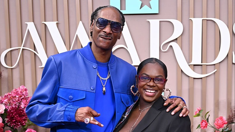 Snoop Dogg poses with his daughter Cori Broadus at a public awards event.