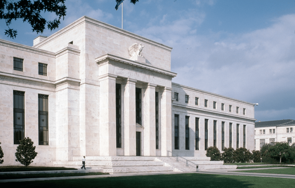 Federal Reserve building with rising gas prices highlighting inflation concerns in the US economy
