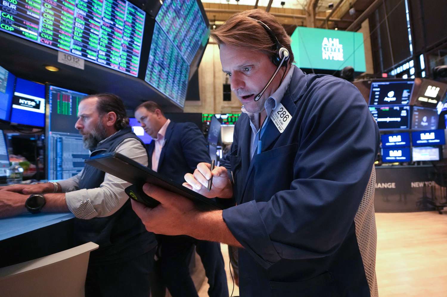 Traders react as UK government bond yields fall during volatile London market trading
