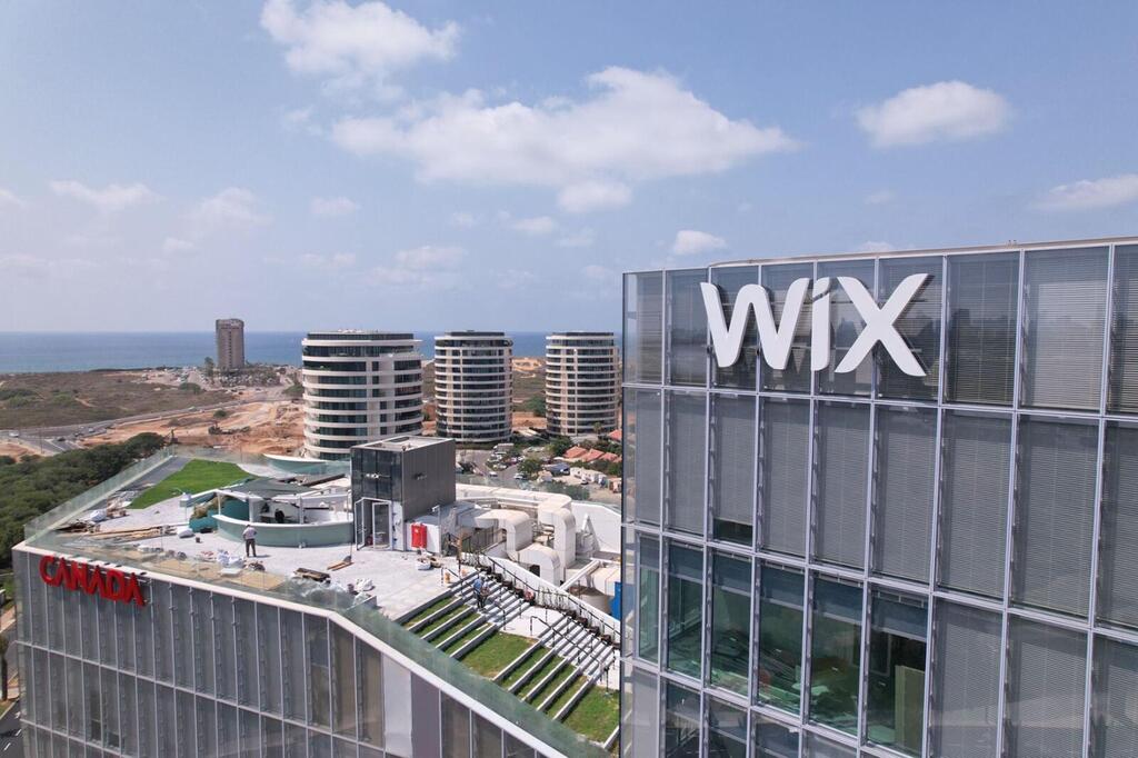 Employees exiting a technology office following Wix job cuts linked to AI pressure.