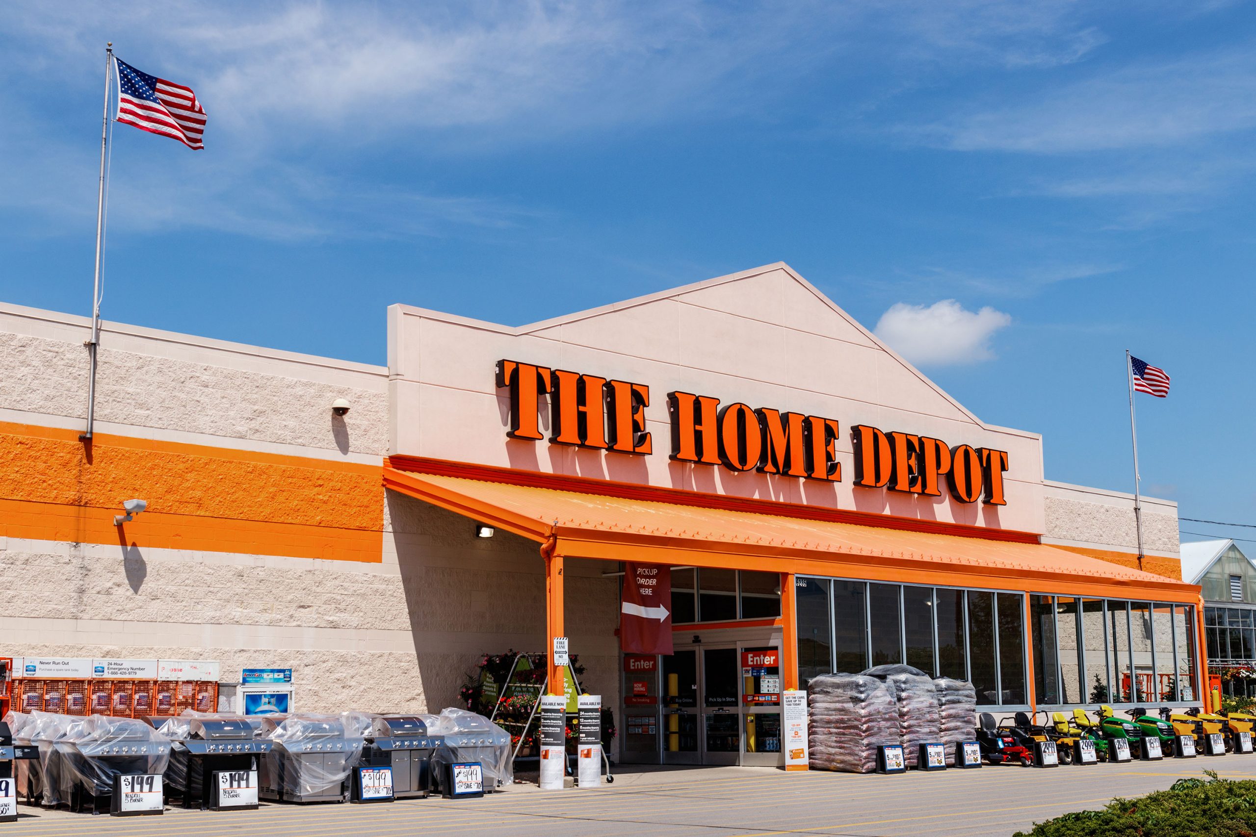 Home Depot store exterior with contractor trucks loading building materials, reflecting housing pressure and slowing U.S. consumer demand