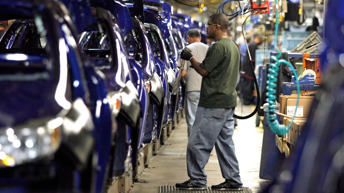 Workers assemble vehicles at a North American automotive manufacturing plant.