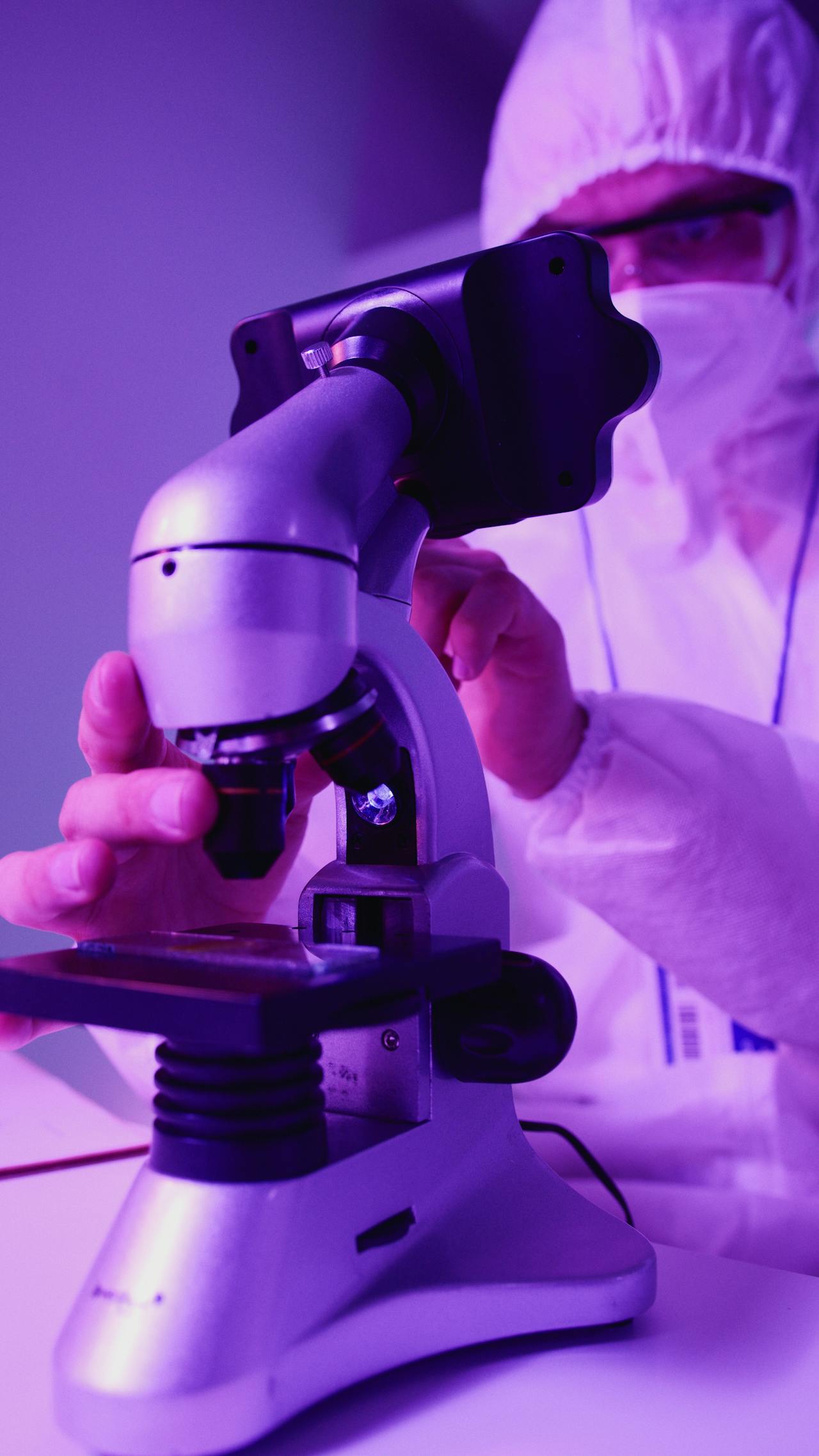 A scientist examines a sample under a microscope, showcasing detailed lab work.