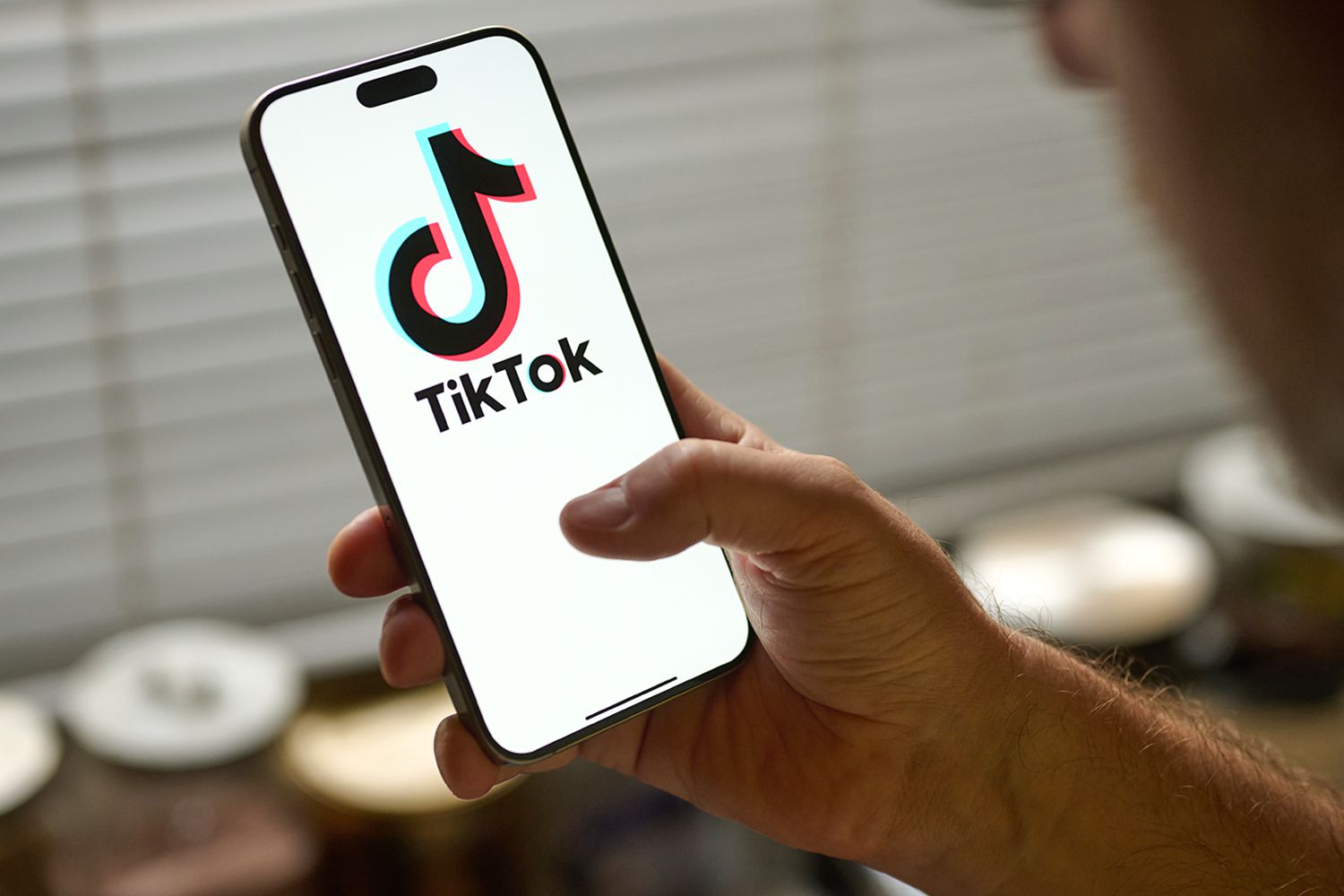 TikTok app logo shown on a smartphone with the U.S. Capitol behind it.