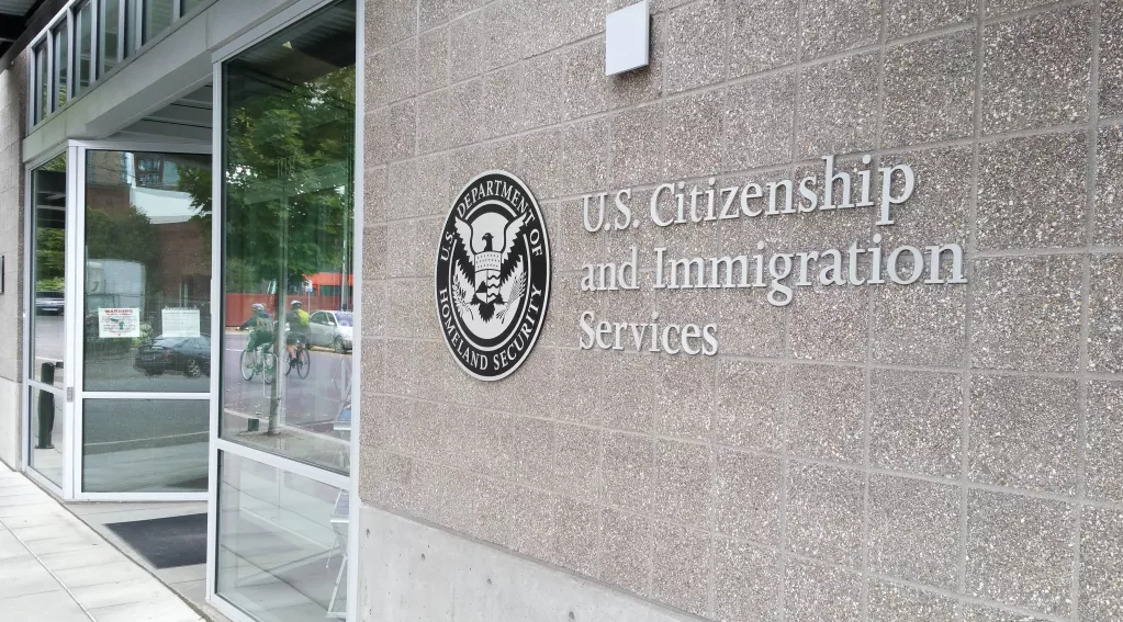 People waiting outside a U.S. immigration office during the green card application process.