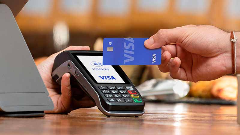 Customer paying with a Visa credit card at a retail checkout terminal