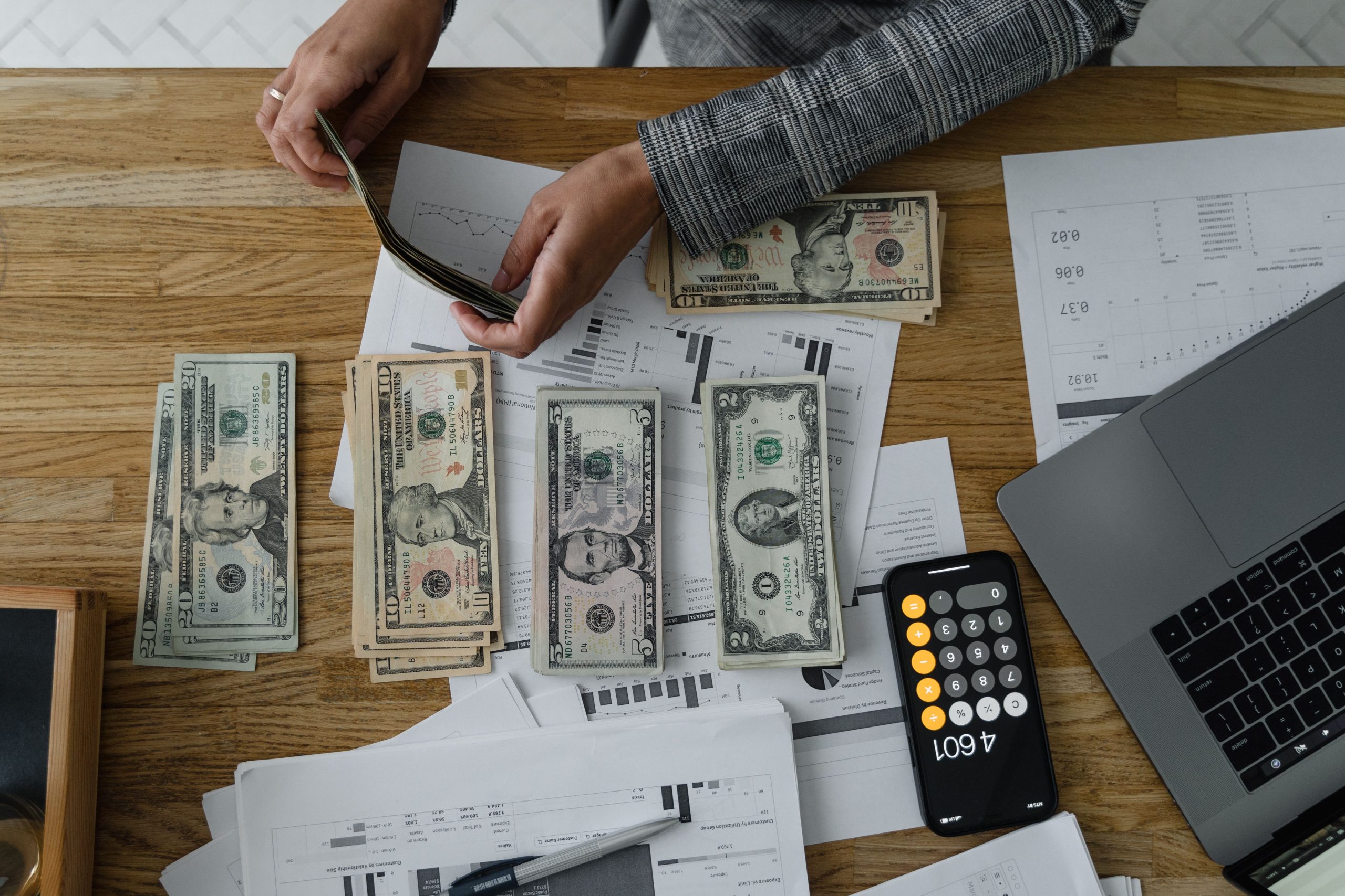 Man at desk counting dollar bills